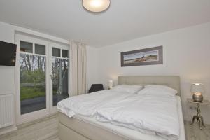 Postel nebo postele na pokoji v ubytování moderne Ferienwohnung mit Sauna und Terrasse - Ferienresidenz Zwei Bodden 112