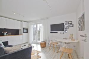 a living room with a couch and a table at moderne 2-Raum-Ferienwohnung mit Balkon - Ferienresidenz Zwei Bodden FeWo 1-4 in Lietzow