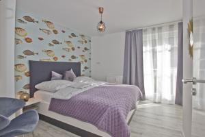 a bedroom with a bed with a purple comforter at moderne 2-Raum-Ferienwohnung mit Balkon - Ferienresidenz Zwei Bodden FeWo 1-4 in Lietzow