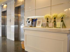 a display case in a lobby with flowers in vases at Hotel AreaOne Obihiro in Obihiro