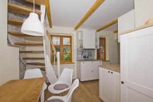 a kitchen with white cabinets and a spiral staircase at strandnahe, schicke FeWo mit Terrasse und Garten - Ferienwohnung Silas in Thiessow +12 photos