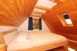 a bed in a room with a wooden ceiling at strandnahe, schicke FeWo mit Terrasse und Garten - Ferienwohnung Silas in Thiessow