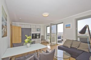 ein Wohnzimmer mit einer Couch und einem Tisch in der Unterkunft Balkon mit Meerblick, ruhige Lage - Ferienhaus Distelfink FeWo 01 in Groß Zicker