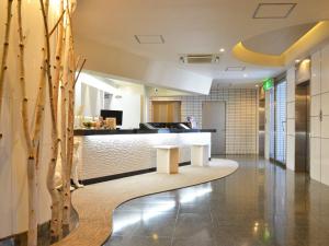 un hall avec un coin d'attente dans un bâtiment dans l'établissement Hotel AreaOne Obihiro, à Obihiro