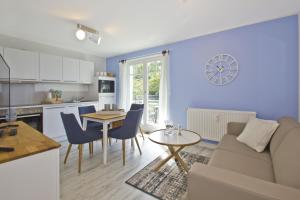 a kitchen and living room with a table and a couch at moderne Ferienwohnung mit Balkon, Meerblick - Ferienresidenz Zwei BoddenFeWo 1-2 in Lietzow