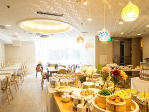un restaurante con mesas y sillas con comida. en Hotel AreaOne Obihiro, en Obihiro
