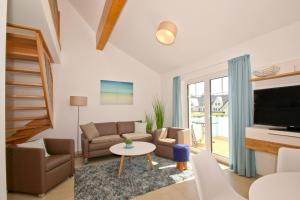 sala de estar con sofá y TV en strandnahe FeWo mit Balkon, gratis Nutzung vom AHOI Erlebnisbad und Sauna in Sellin - Rex Rugia FeWo 11-6, en Lobbe