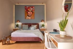 a bedroom with a bed with a painting on the wall at Arolithos Home in Almirida