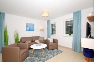 ein Wohnzimmer mit einer Couch und einem Tisch in der Unterkunft strandnahe FeWo mit Terrasse, gratis Nutzung vom AHOI Erlebnisbad und Sauna in Sellin - Rex Rugia FeWo 11-1 in Lobbe