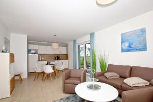 ein Wohnzimmer mit einer Couch und einem Tisch in der Unterkunft strandnahe FeWo mit Terrasse, gratis Nutzung vom AHOI Erlebnisbad und Sauna in Sellin - Rex Rugia FeWo 11-1 in Lobbe