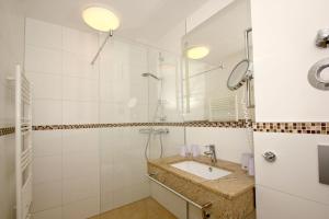 ein Badezimmer mit Waschbecken und Dusche in der Unterkunft strandnahe FeWo mit Terrasse, gratis Nutzung vom AHOI Erlebnisbad und Sauna in Sellin - Rex Rugia FeWo 11-1 in Lobbe
