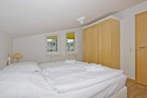 a white bed in a room with two windows at mit Meerblick und Balkon, gratis Nutzung vom AHOI Erlebnisbad und Sauna in Sellin - Meeresblick FeWo 16 in Göhren +13 photos
