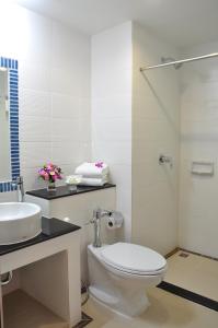 a bathroom with a toilet and a sink and a shower at Mayflower Grande Hotel Chiang Mai in Chiang Mai