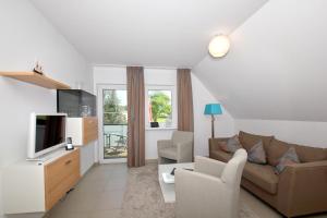ein Wohnzimmer mit Sofa und Fernseher in der Unterkunft strandnahe FeWo mit Balkon, gratis Nutzung vom AHOI Erlebnisbad und Sauna in Sellin - Rex Rugia FeWo 30-8 in Lobbe