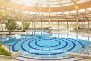 a large swimming pool in a large building at strandnahe FeWo mit Terrasse, gratis Nutzung vom AHOI Erlebnisbad und Sauna in Sellin - Rex Rugia FeWo 14-1 in Lobbe