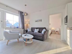 a living room with a couch and a table at modernen Ferienwohnung mit eigener Terrasse - Haus Inselwind FeWo MEERküste in Groß Zicker