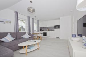 a living room with a couch and a table at moderne Ferienwohnung mit Gartennutzung - Haus Inselwind FeWo MEERbucht in Groß Zicker