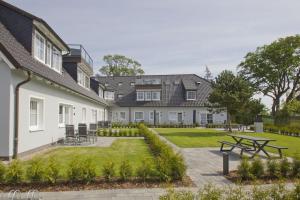 a courtyard of a house with a picnic table at moderne Ferienwohnung mit Gartennutzung - Haus Inselwind FeWo MEERbucht in Groß Zicker