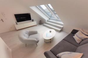 a living room with a couch and a tv at Ferienwohnung mit Dachterrasse und Meerblick - Haus Inselwind FeWo MEERwasser in Groß Zicker