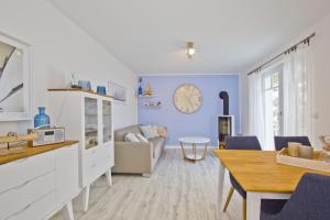 cocina y sala de estar con reloj en la pared en moderne Ferienwohnung mit Balkon, Meerblick - Ferienresidenz Zwei BoddenFeWo 1-3, en Lietzow