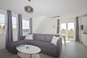 a living room with a couch and a table at mit Meerblick, gratis Nutzung vom AHOI Erlebnisbad und Sauna in Sellin - Haus Inselblick FeWo MEERrauschen in Groß Zicker