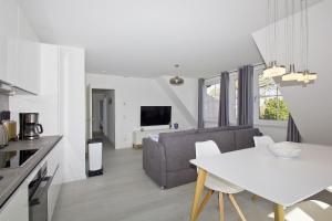 a kitchen and living room with a table and a couch at mit Meerblick, gratis Nutzung vom AHOI Erlebnisbad und Sauna in Sellin - Haus Inselblick FeWo MEERrauschen in Groß Zicker