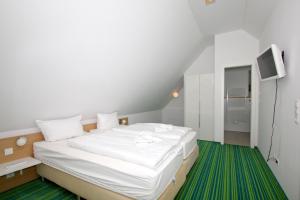 a bedroom with a large white bed with a green rug at strandnahe FeWo mit Balkon, gratis Nutzung vom AHOI Erlebnisbad und Sauna in Sellin - Rex Rugia FeWo 30-5 in Lobbe