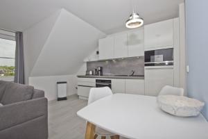 a kitchen and living room with a white table and chairs at gratis Nutzung vom AHOI Erlebnisbad und Sauna in Sellin - Haus Inselwind FeWo MEERwind in Groß Zicker