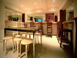 a kitchen with a dining table and some chairs at Silom One in Bangkok