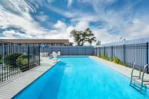 a swimming pool with a fence and a blue swimming pool at Days Inn by Wyndham Panama City in Panama City