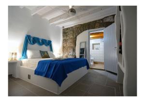 a bedroom with a blue bed with a blue curtain at Salty Splash & Kyma Sirma Klima in Klima