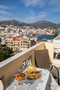 a table with a plate of bread and two glasses of orange juice at Amalthia Apartment in Karpathos Town