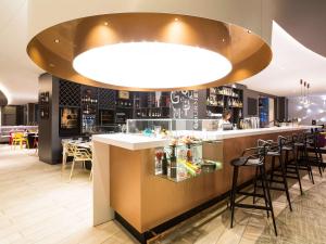 a bar in a restaurant with a large light at Novotel Resort & Spa Biarritz Anglet in Anglet