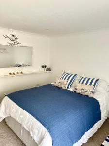 a bedroom with a bed with blue and white pillows at Luna Beach - Luxury Carbis Bay Apartment With Parking in Carbis Bay