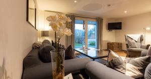 a living room with a couch and a vase with flowers at Appartementanlage am Arnumer See in Hemmingen