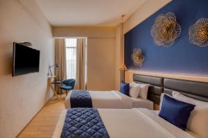 a hotel room with two beds and a tv at Le Foliage by TGI in Bangalore