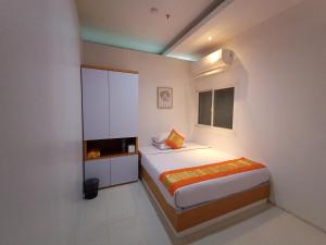a small bedroom with a bed and a window at Arawa Traveller's Inn Motel in Makassar
