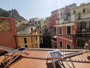 a balcony with two chairs and a laptop on it at SeaBreeze Vernazza in Vernazza