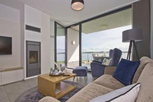 a living room with a couch and a table at eigene Sauna, moderne Ferienwohnung in Wassernähe mit Meerblick - Ferienwohnung Heimathafen, gratis Nutzung vom AHOI Erlebnisbad und Sauna in Sellin in Alt Reddevitz