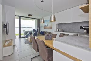 a kitchen and dining room with a table and chairs at eigene Sauna, moderne Ferienwohnung in Wassernähe mit Meerblick - Ferienwohnung Heimathafen, gratis Nutzung vom AHOI Erlebnisbad und Sauna in Sellin in Alt Reddevitz