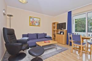 a living room with a blue couch and a table at Balkon, gratis Nutzung vom AHOI Erlebnisbad und Sauna in Sellin - Appartemenmt Nordwind in Baabe