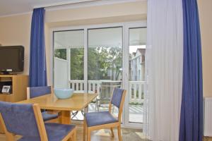a dining room with a table and chairs and a window at Balkon, gratis Nutzung vom AHOI Erlebnisbad und Sauna in Sellin - Appartemenmt Nordwind in Baabe