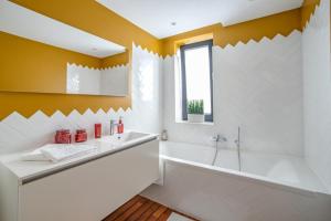 une salle de bain avec une baignoire et un lavabo dans l'établissement Au bois du Sart-Tilman, à Sur le Mont 8 autres photos