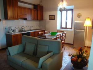 sala de estar y cocina con sofá y mesa en Agriturismo Fattoria il Piano - Casa Bugno - San Gimignano, en San Gimignano