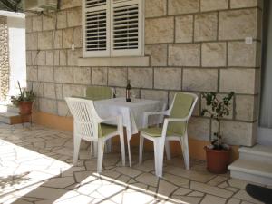 a white table and chairs on a patio at Apartments Ivona in Lumbarda +42 photos