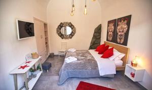 a bedroom with a bed with red pillows and a mirror at b&b le onde praiola in Terrasini