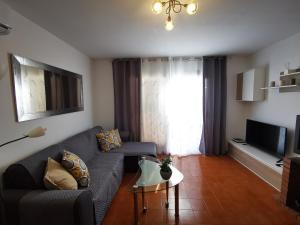 - un salon avec un canapé et une télévision dans l'établissement Apartment Hibiscus, à Cala Pi