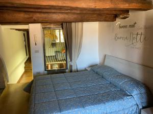 a bedroom with a blue bed and a window at La casetta nel granaio in Capranica