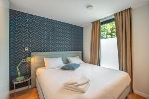 une chambre avec un lit avec deux serviettes dessus dans l'établissement Au bois du Sart-Tilman, à Sur le Mont