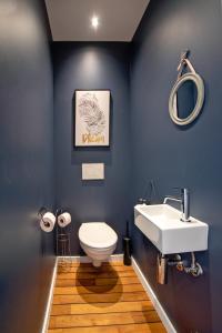 une salle de bain avec des toilettes blanches et un lavabo dans l'établissement Au bois du Sart-Tilman, à Sur le Mont